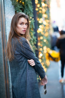 İtalya, Milan 'da poz veren çekici genç bir kadın. Güzel kız Noel süslemeleri ve yeni yıl tatilleriyle Milano sokaklarında yürüyor.. 