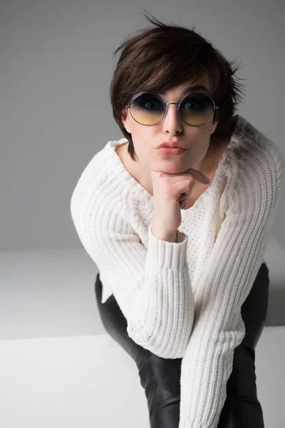 Young Woman Sunglasses Sitting White Cube Studio Isolated Gray Background — Stock Photo, Image