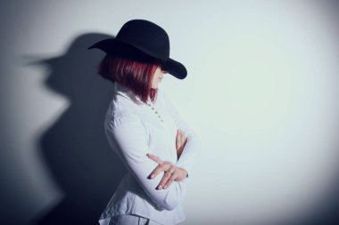 Siyah şapkalı ve beyaz gömlekli gizemli bir kadın. Fotokopi alanı. Reklam mesajı nerede yazılabilir?