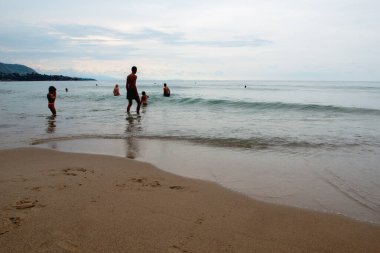 Günbatımında Sicilya 'da (İtalya) sakin Akdeniz' de yüzen insanlar