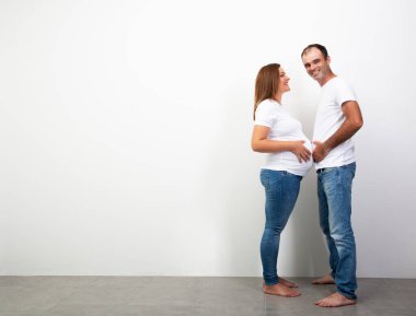 Hamilelik. Mutlu Aile Bebek Bekliyor. Erkek ve hamile kadın göbekleriyle ölçülür. Çift yaşam tarzı