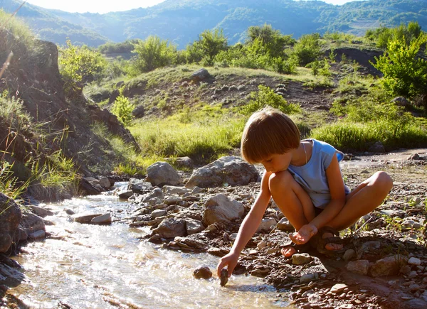 Ragazzo giocare sul fiume di montagna — Foto Stock