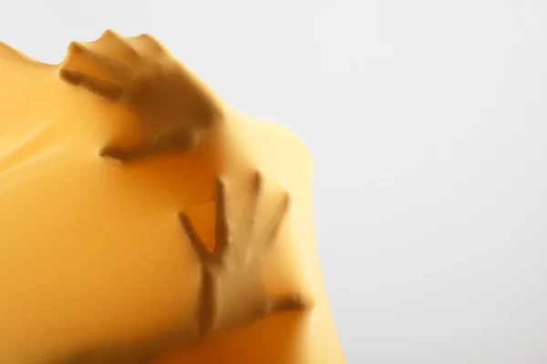 Mänsklig arm inuti gult tyg — Stockfoto