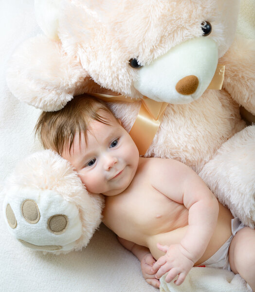 Infant baby boy with big toy bear
