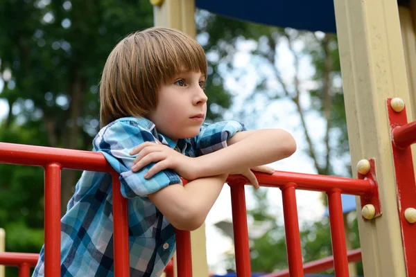 Jongen spelen op de speelplaats — Stockfoto