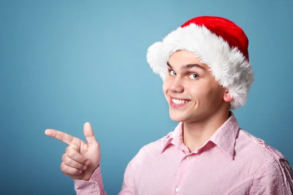 Man with santa's hat point with hand left — Stock Photo, Image