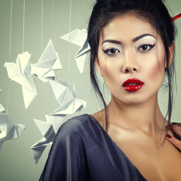 Asian woman with origami paper pigeons — Stock Photo, Image