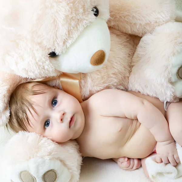 Infant baby boy with big toy bear