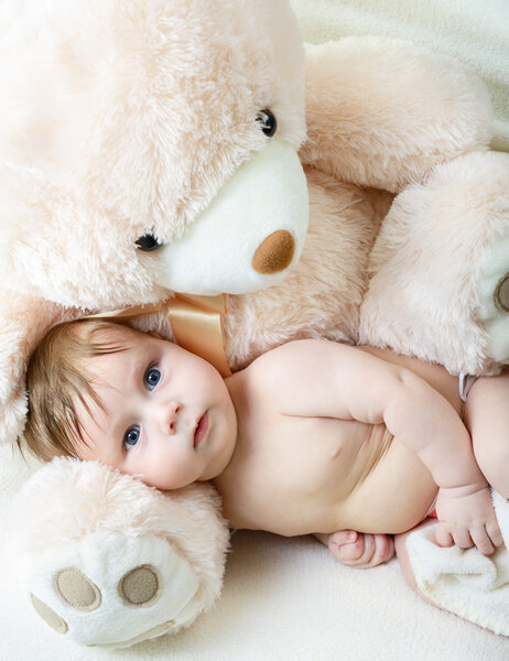 Infant baby boy with big toy bear