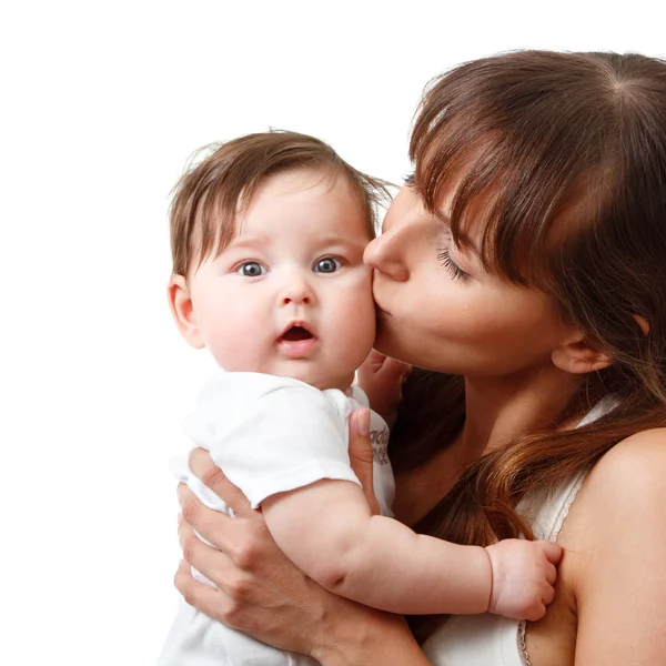 Jovem mãe beijo bonito sorrindo bebê — Fotografia de Stock