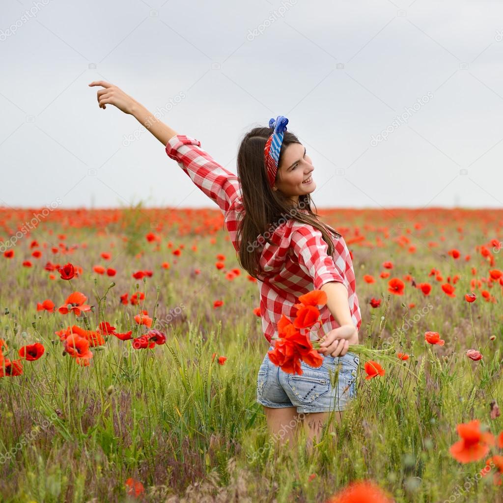 Woman dancing on poppy field