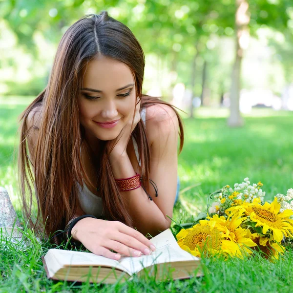 Vrolijk meisje leesboek in park — Stockfoto