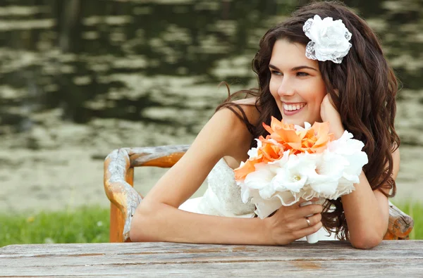 Bride with flowers in summer park — Stock Photo, Image
