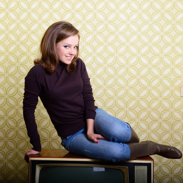Leende kvinna som sitter på retro tv — Stockfoto