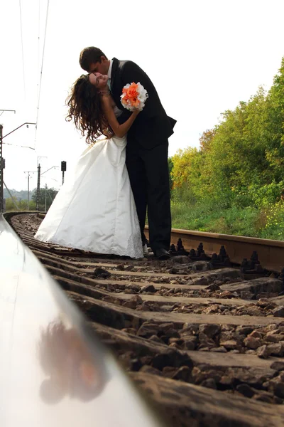 Bride with groom in love on railway — Stock Photo, Image