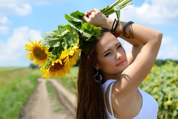 Beautiful woman holding sunflowers — Stock Photo, Image