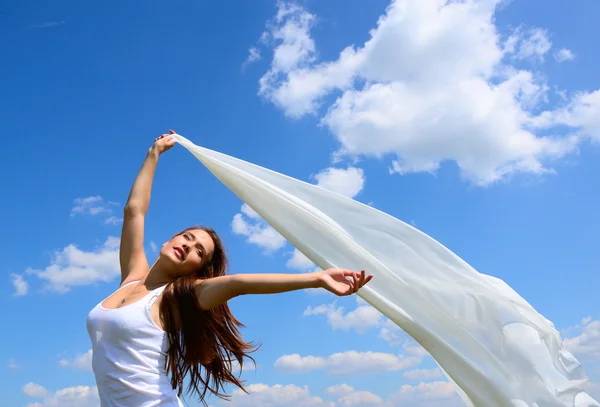 Woman holding white scarf against sky — Stock Photo, Image