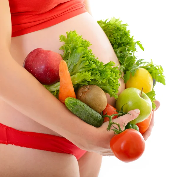 Gravid kvinna med frukt och grönsaker — Stockfoto