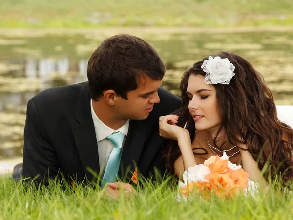 Bride lying together with groom in love — Stock Photo, Image