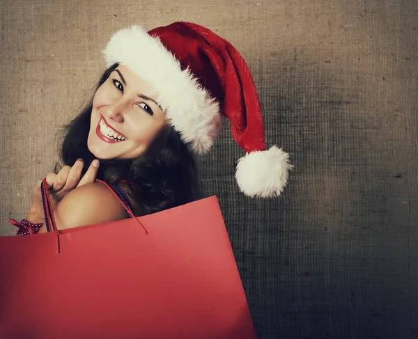 Mujer en sombrero de santa con bolsas de compras — Foto de Stock