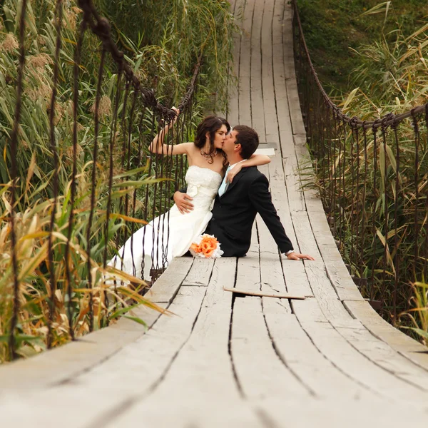 Bella sposa con goom sul ponte — Foto Stock
