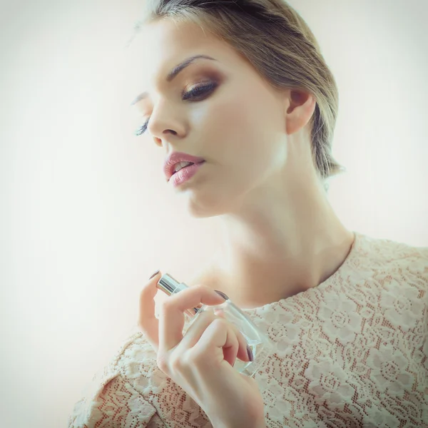 woman holding bottle of perfume