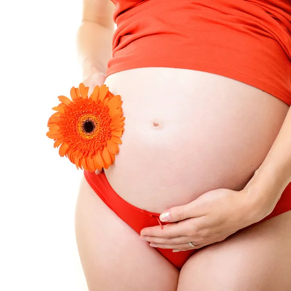 Gravid kvinna med orange blomma — Stockfoto