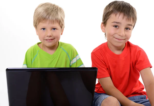 Portrait of smart schoolboys looking at the laptop, over white — Stock Photo, Image