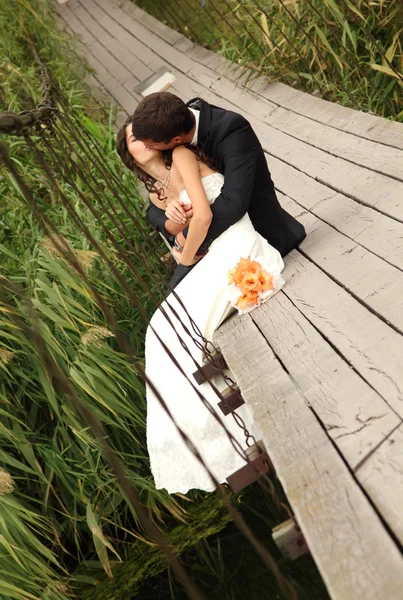 Krásná nevěsta s goom na mostě — Stock fotografie