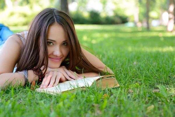 Tyttö lukeminen kirja kesäpuistossa — kuvapankkivalokuva