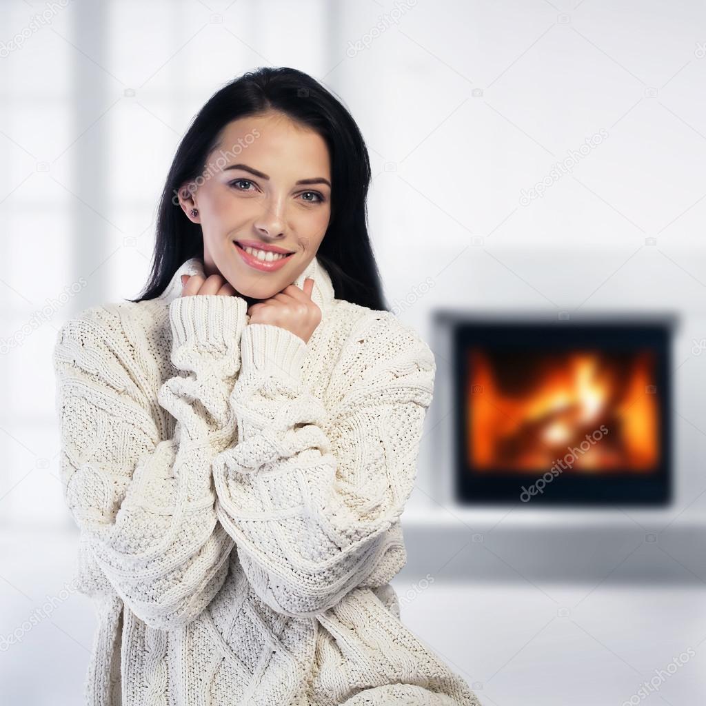 Woman relaxing by the fireplace