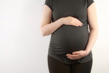 Hamile kadın karnına dokunuyor.