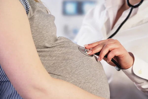 Médico examinando uma mulher grávida — Fotografia de Stock