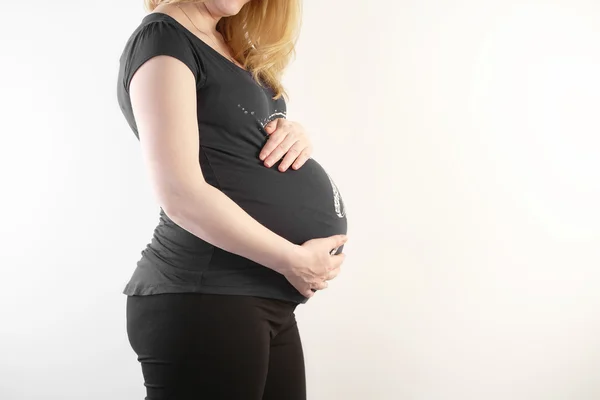 Schwangere berührt ihren Bauch — Stockfoto