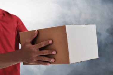 Karton kutu taşıyan teslimatçı.