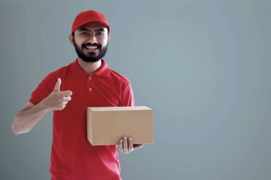 Elinde karton kutu tutan gülümseyen teslimatçı.