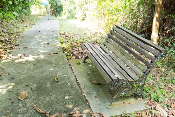 Banco a lo largo de la acera en el parque . —  Fotos de Stock