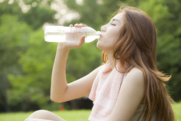 Vrouw zitten en drinken na de oefening. — Stockfoto