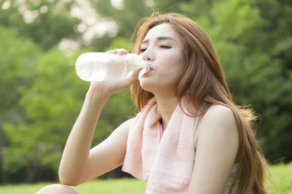 Vrouw zitten en drinken na de oefening. — Stockfoto