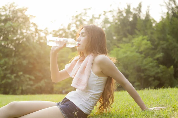 Mujer sentarse y beber después del ejercicio . —  Fotos de Stock