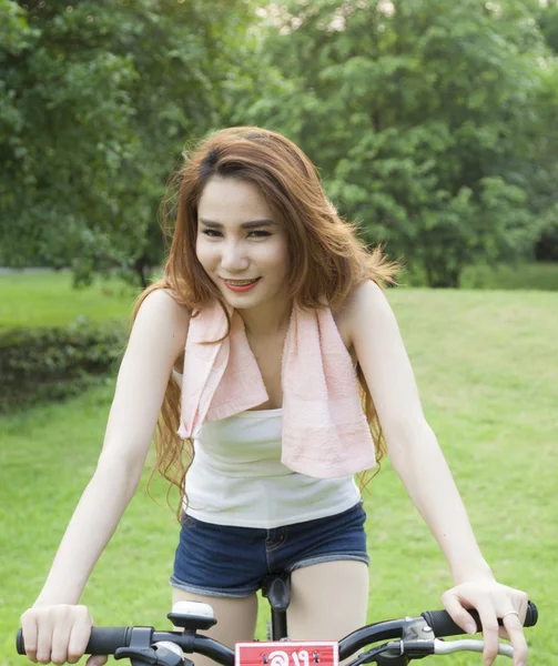 Mujer montando una bicicleta estática en el parque . —  Fotos de Stock