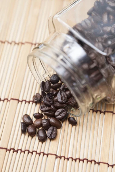 Kaffebönor spillt från flaska — Stockfoto