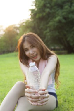 bir şişe su tutarak ve ona uzattı kadın.