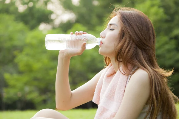 Mujer sentarse y beber después del ejercicio . —  Fotos de Stock