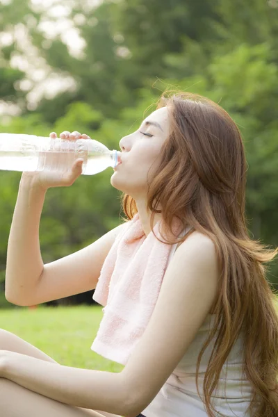 Mujer sentarse y beber después del ejercicio . —  Fotos de Stock