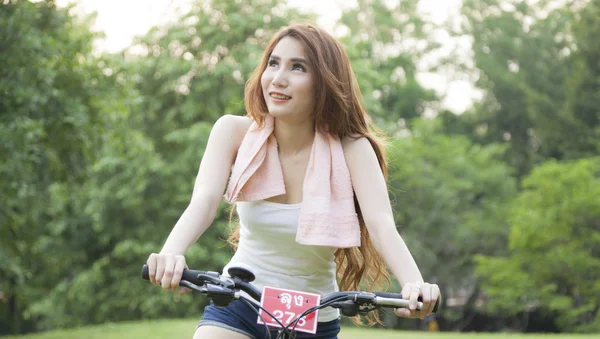 Mujer montando una bicicleta estática en el parque . —  Fotos de Stock