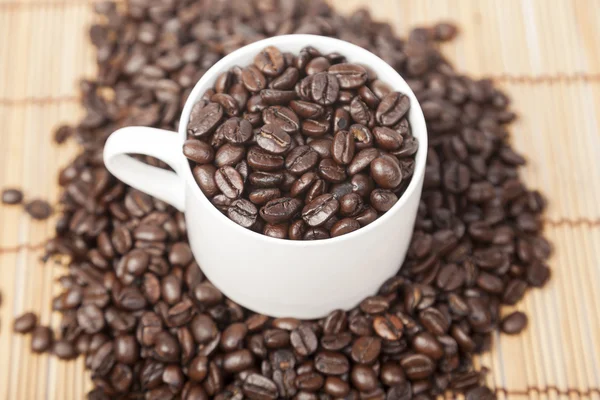 Granos de café en taza de café —  Fotos de Stock