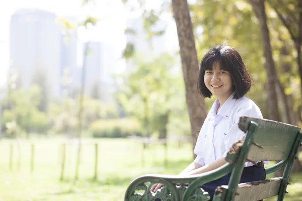 Écolière assise sur le banc . — Photo