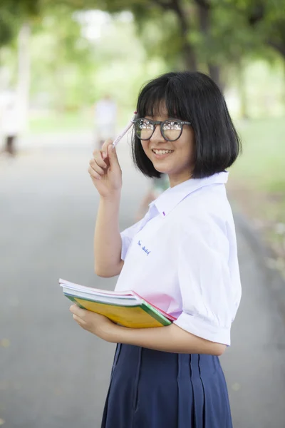 Schoolgirl standing holding a book. — Stock Photo, Image