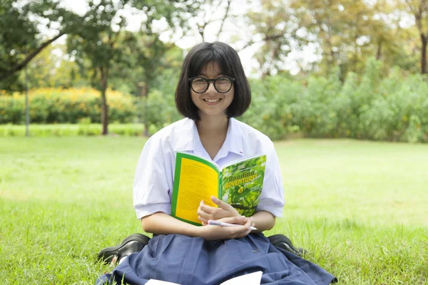 Mädchen hält ein Buch und lächelt. — Stockfoto